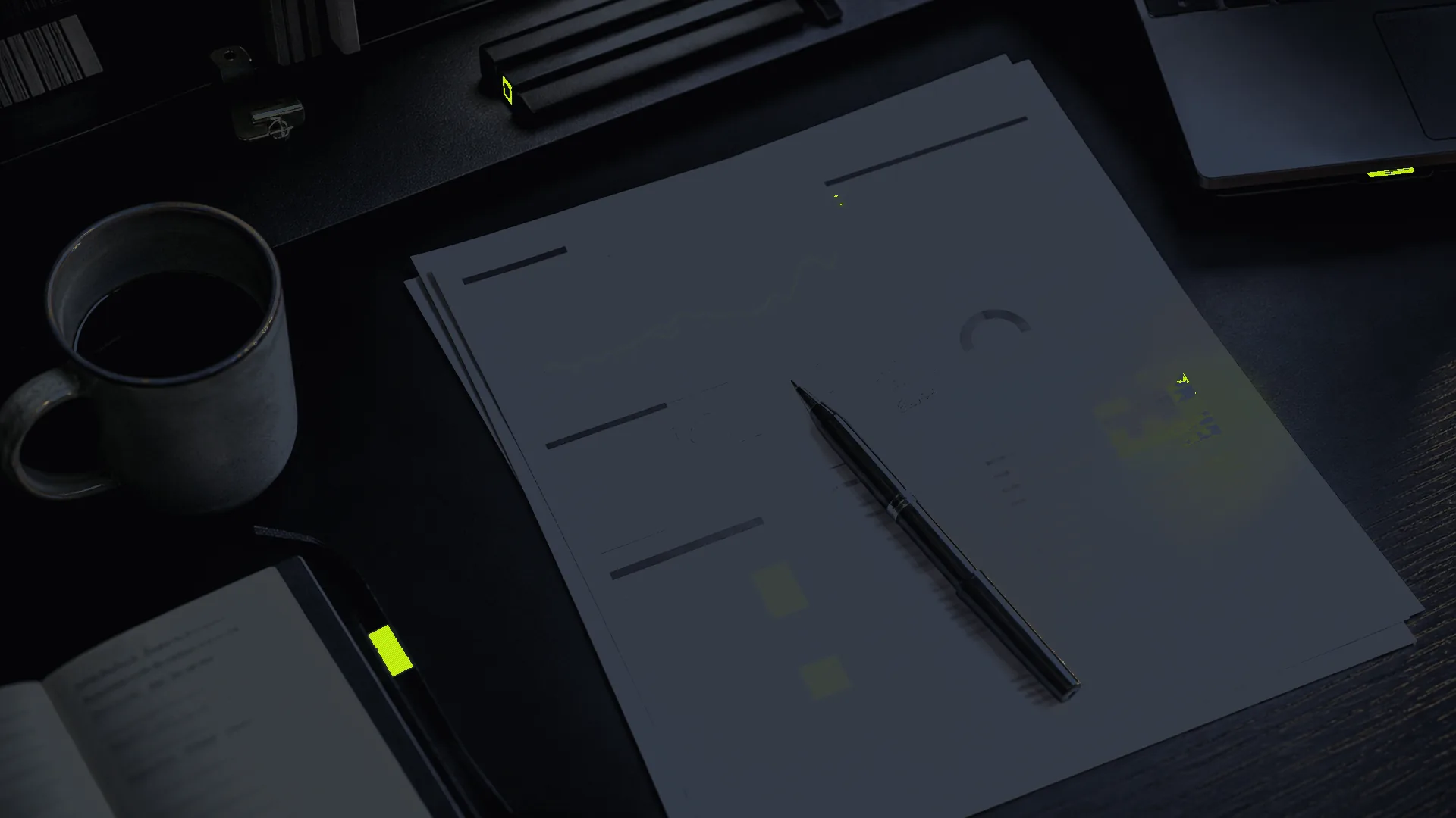 Dark desk with an audit packet, pen, notebook, and yellow proof marks.