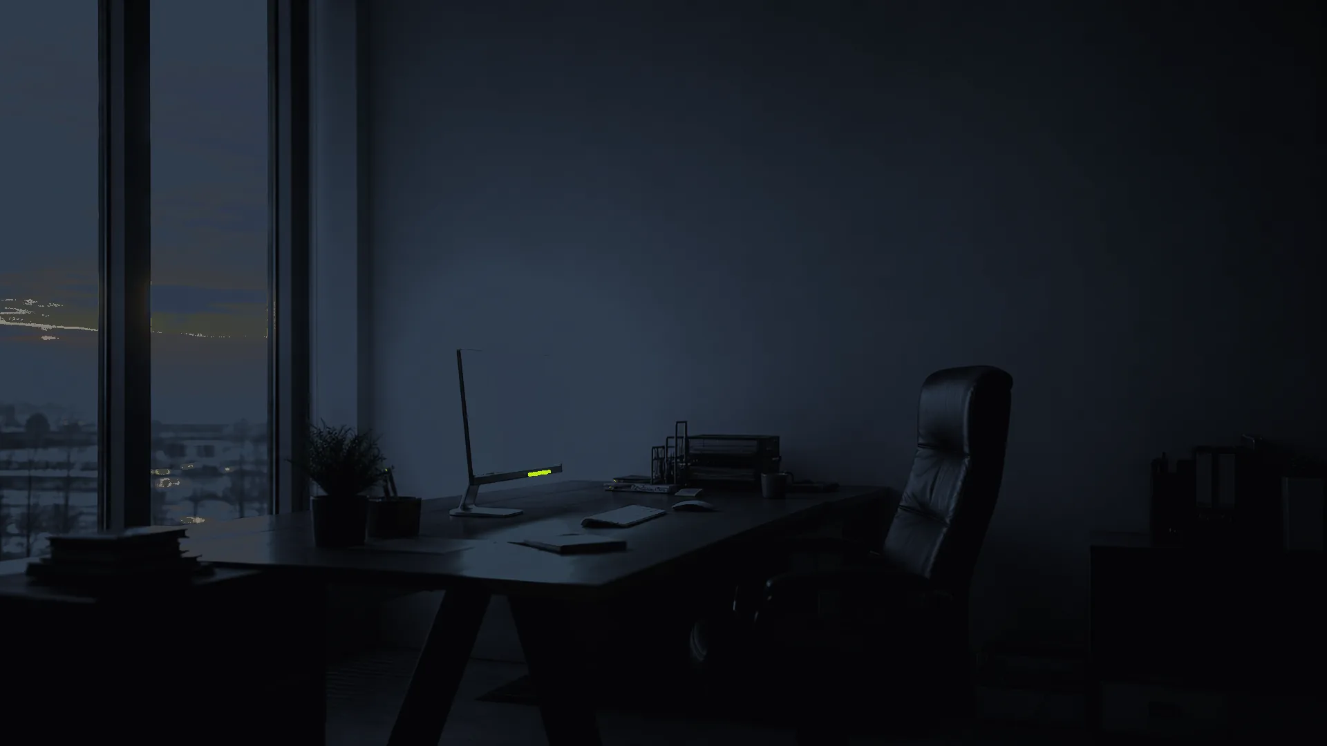 An operator's hands at a laptop keyboard at first light, a faint dashboard on a second monitor showing a single accent metric — the system running quietly while the work continues.